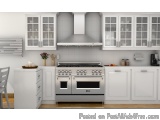 The image shows a modern kitchen with white cabinets and a stainless steel range hood above the stove. The range hood is made...