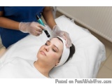 The image shows a young woman lying on a white bed with a white headband on her head. She is wearing a white t-shirt and appe...