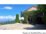 The image shows a beautiful view of a house with a stunning view of the mountains in the background. The house is a two-story...