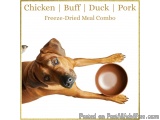 The image is a photograph of a brown dog, possibly a Rhodesian Ridgeback, holding a bowl of freeze-dried meal. The dog is loo...