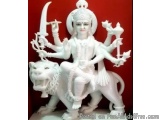 The image is a photograph of a statue of the Hindu goddess Durga. She is sitting on a lion, which is also white in color. Dur...