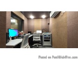 The image shows a modern office space with a desk and two computer monitors. The desk is white and has a computer monitor, ke...