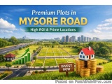 The image is an advertisement for premium plots in Mysore Road, a high ROI and prime locations in India. The background of th...