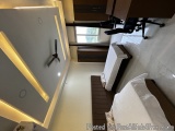 The image shows a modern and minimalist bedroom with a minimalist design. The room has a white tiled floor and a gray wall on...