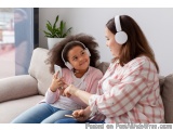 The image shows a mother and daughter sitting on a couch in a living room. The daughter is wearing a pink shirt and has curly...