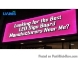 The image shows a large pink LED signboard with white text that reads "Looking for the Best LED Sign Board Manufacturers Near...