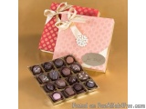 The image shows a small gift box with a pink polka dot pattern and a white ribbon tied around it. The box is rectangular in s...
