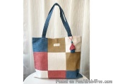 The image is of a tote bag with a patchwork design. The bag is made of a combination of different colors and textures, includ...