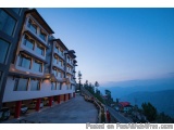 The image shows a beautiful view of a hotel building on a hillside. The building is a two-story structure with multiple floor...