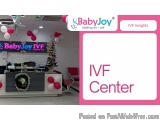 The image shows the interior of a babyjoy IVF center. The center is decorated with pink and white balloons, a Christmas tree,...