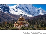 The image shows a beautiful landscape of a mountain range with a temple in the foreground. The temple is a traditional Buddhi...