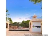 The image shows the entrance gate of a building named Club Mahindra Bharatpur. The gate is made of black metal and has a deco...