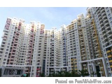 The image shows a tall, multi-storey building with multiple floors and balconies. The building appears to be made of concrete...