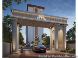 The image is a 3D rendering of the entrance of a modern building named "Vesta". The entrance is made of stone pillars and has...