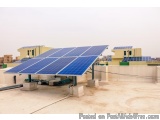 The image shows a rooftop of a building with multiple solar panels installed on it. The panels are arranged in a grid-like pa...