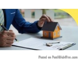 The image shows a person's hand holding a pen and writing on a piece of paper. The person is wearing a blue suit and tie and...