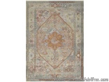 The image is of a rectangular area rug with a traditional oriental design. The rug has a beige background with a blue border...