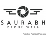 The image is a logo for a company called "Saurabh Drone Wala". The logo is black and white and features a circular camera len...