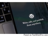 The image is a close-up of a laptop screen with the WordPress logo on it. The background of the screen is black and the text...