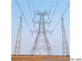 The image shows three tall electricity pylons in an open field. The towers are made of steel and have a lattice-like structur...