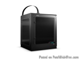 The image shows a black 3D printer with a handle on top. The printer is rectangular in shape and has a sleek, modern design....