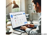 The image shows a man sitting at a desk with a laptop in front of him. He is wearing a blue shirt and appears to be working o...