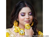 The image is a close-up portrait of a young woman with dark hair styled in loose curls. She is wearing a traditional Indian o...