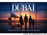 The image shows a group of four people walking towards an airplane at sunset. The sky is a beautiful orange and pink color, i...