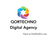 The image is a logo for a digital agency called Qortechno Digital Agency. The logo is a circular shape with a colorful design...