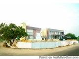 The image shows a two-story building with a modern design. The building is painted in a combination of white, yellow, and gre...