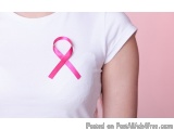 The image shows a person wearing a white t-shirt with a pink ribbon on it. The ribbon is a symbol of breast cancer awareness...