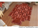 The image shows a rectangular area rug in a living room. The rug is made of a soft, plush material and has a red color with a...
