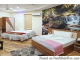 The image shows a modern and spacious bedroom with two single beds. The beds are made up with white linens and pink bedspread...