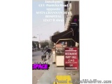 The image shows a street scene in Janakpur, India. The street is lined with buildings and there is a motorcycle parked on the...