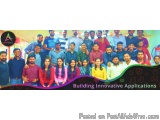 The image is a group photo of a group of people posing for a photo in front of a colorful background. The group is arranged i...