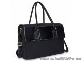 The image is of a black handbag with a long, rectangular shape. The bag has a top handle and a detachable shoulder strap. It...