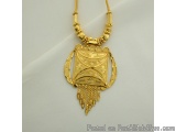The image is of a gold necklace with a pendant. The pendant is in the shape of a shield with intricate designs and patterns o...
