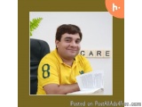 The image is a portrait of a young man sitting at a desk with a book in front of him. He is wearing a yellow polo shirt with...