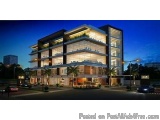 The image is a 3D rendering of a modern apartment building at night. The building is a two-story structure with a flat roof a...