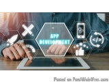 The image shows a person's hands holding a tablet with the word "APP DEVELOPMENT" written on it. The tablet is placed on a wo...