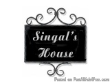 The image is of a black rectangular sign with the words "Singal's House" written in white capital letters. The sign is attach...
