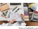 The image shows a desk with a laptop, a notebook, a color swatch, and a stack of fabrics. On the desk, there is also a person...