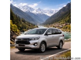 The image shows a silver Toyota Innova SUV driving on a winding mountain road. The car is in the center of the image, with th...