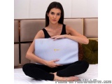 The image shows a young woman sitting on a bed with a laptop in her hands. She is wearing a black tank top and black leggings...