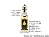 The image shows a bottle of cold-pressed pure organic argan oil. The bottle is made of glass and has a silver cap. The label...