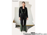 The image shows a young woman wearing a tracksuit. The tracksuit is black with green accents on the sides and back. The woman...