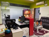 The image shows an office space with a modern design. The walls are painted in a bright green color and there is a large wind...