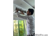 The image shows a man in a white shirt hanging from the ceiling with a ladder. He is holding onto the ladder with both hands...