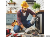 In this image, we can see a man wearing a yellow hard hat and overalls, kneeling on the floor in front of an oven. He is wear...