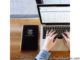 The image shows a person's hands typing on a laptop keyboard. The laptop is open and the screen is displaying a webpage with...